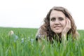 Portrait of romantic, young woman with short hair lying on green grass, dreams