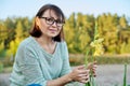 Portrait of 40s woman looking at camera with blooming flowers Royalty Free Stock Photo