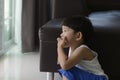 Sad asian little boy sitting on the floor and thinking about something Royalty Free Stock Photo