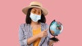 Sad Asian Woman In Mask Holding Globe, Pointing At Map Royalty Free Stock Photo