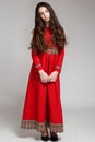 Portrait of a sad brunette girl with long hair in a red dress Royalty Free Stock Photo