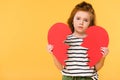 portrait of sad child with broken red paper heart