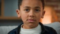 Portrait sad cute little African American boy looking down look at camera. Close up ethnic multiracial multiethnic child Royalty Free Stock Photo