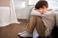 Portrait of sad depressed american cute little boy child alone sitting on floor at home Royalty Free Stock Photo