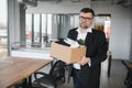 Portrait of sad dismissed senior old business man worker taking his office supplies in the box. Pensioner mature retire Royalty Free Stock Photo