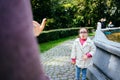 Portrait sad down syndrome girl standing in front of her mother with a sad face. Child with a disability is naughty and Royalty Free Stock Photo