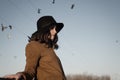 Portrait of sad elegant girl outdoor with pigeons in the autumn sky