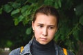 Portrait of a sad girl in a Park on a background of greenery close-up Royalty Free Stock Photo