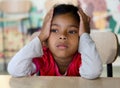 Portrait of a sad little girl sitting at the table in the classroom Royalty Free Stock Photo