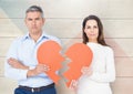 Portrait of sad mature couple holding broken hearts Royalty Free Stock Photo