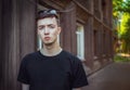 Portrait of sad and pensive handsome young man standing near old building Royalty Free Stock Photo