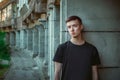 Portrait of sad and pensive handsome young man standing near old building