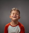 Portrait of a sad pretending cry little boy isolated on grey background. Fake emotions. Human emotions, facial Royalty Free Stock Photo