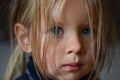 Portrait of a sad romantic little girl with big blue eyes from Eastern Europe, close-up, dark background Royalty Free Stock Photo