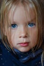 Portrait of a sad romantic little girl with big blue eyes from Eastern Europe, close-up, dark background Royalty Free Stock Photo