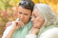 Portrait of sad senior woman with adult daughter in autumnal park Royalty Free Stock Photo