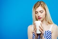 Portrait of Sad Serious Girl with Closed Eyes Holding White Candle in Her Hands. Beautiful Blonde with Bare Shoulders Royalty Free Stock Photo