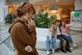 Portrait of sad serious teenager guy wearing headphones alone at shopping mall Royalty Free Stock Photo