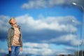 Portrait sad and stressed young woman suffering migraine headache, blue sky and clouds as background.