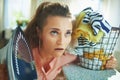 Woman with iron and clothes basket at modern home in sunny day Royalty Free Stock Photo