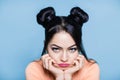Portrait of sad and upset brunette woman with hair of mouse on blue background Royalty Free Stock Photo