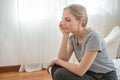 Portrait of sad upset worry and depressed young caucasian woman sit on bed in home with sorrow,hopeless,unhappy in trouble emotion