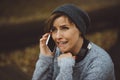 Portrait of sad woman sitting alone in the forest with smartphone. Solitude concept. Millenial dealing with problems and Royalty Free Stock Photo