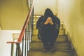 Portrait of sad young man covering his face with hands sitting on old stairs. Royalty Free Stock Photo