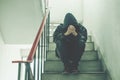 Portrait of sad young man covering his face with hands sitting on old stairs. Royalty Free Stock Photo