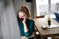 Portrait of sad young woman with face mask indoors at home. Royalty Free Stock Photo