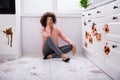 Sad Woman Sitting In Messy Kitchen Royalty Free Stock Photo