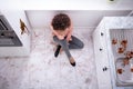 Sad Woman Sitting In Messy Kitchen Royalty Free Stock Photo