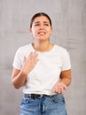 Sad young woman posing crossly against gray background Royalty Free Stock Photo