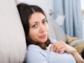 Sad young woman thinking on sofa in home interior Royalty Free Stock Photo