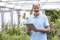 Portrait Of Sales Assistant In Garden Center With Digital Tablet Royalty Free Stock Photo