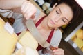 portrait saleswoman cutting cheese