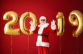 Portrait of Santa Claus with balloons in shape of figures 2019 on color background Royalty Free Stock Photo