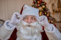 Portrait of Santa Claus with glasses near the fireplace and christmas tree with gifts. New year and Merry Christmas , happy Royalty Free Stock Photo