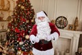 Portrait of Santa Claus showing thumb up near the fireplace and christmas tree with gifts. New year and Merry Christmas , happy Royalty Free Stock Photo