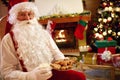 Portrait Santa Claus sitting and enjoying in cookies and milk Royalty Free Stock Photo