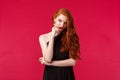 Portrait of sassy and seductive young elegant woman with red ginger hair, wearing black dress, evening makeup and red Royalty Free Stock Photo