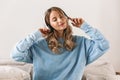 Portrait of satisfied blond girl 20s wearing headphones smiling and listening to music at home Royalty Free Stock Photo