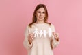 Satisfied woman holding paper chain people which holding in hands, happy family, relationships. Royalty Free Stock Photo