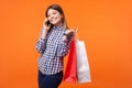 Portrait of satisfied buyer, happy brunette woman with charming smile. indoor studio shot isolated on orange background