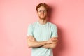 Portrait of satisfied caucasian man with red hair and beard, cross arms on chest and smiling with smug face, wearing Royalty Free Stock Photo