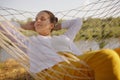 Portrait of satisfied Caucasian young adult woman having nap in hammock on the bank of the river, lying with closed eyes, sleeping Royalty Free Stock Photo