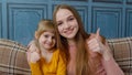 Portrait of satisfied child kid daughter with young mother, hugging, embracing, showing thumbs up Royalty Free Stock Photo