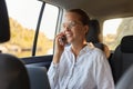 Portrait of satisfied delighted business woman sitting in the car and talking on the cell phone, female in a car having pleasant Royalty Free Stock Photo