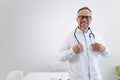 Portrait of a satisfied doctor in a medical gown and stethoscope in the office