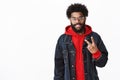 Portrait of satisfied and friendly good-looking african guy in glasses with beard posing in denim jacket over hoodie